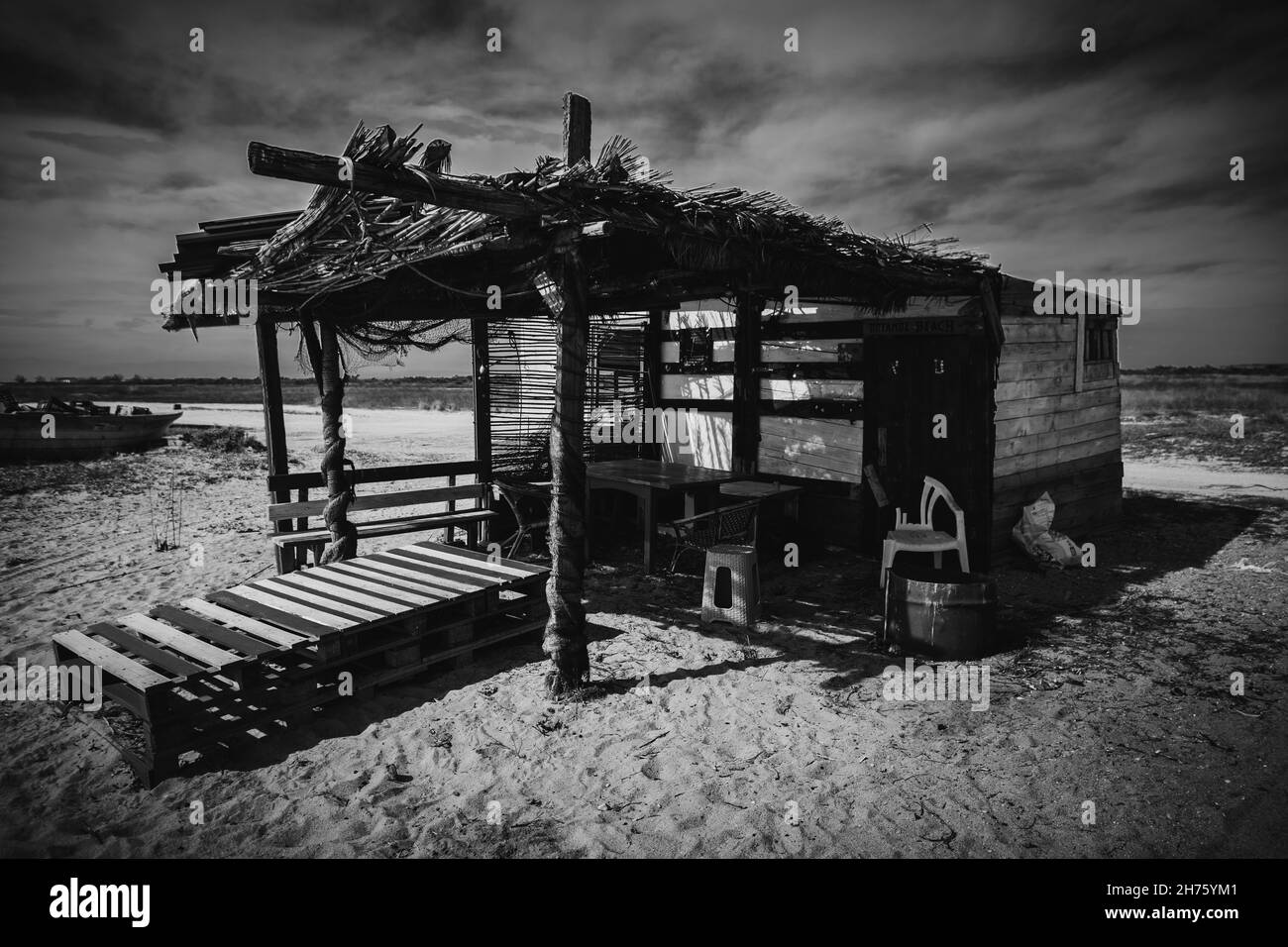 Small straw house on a sandy beach on a grayscale Stock Photo