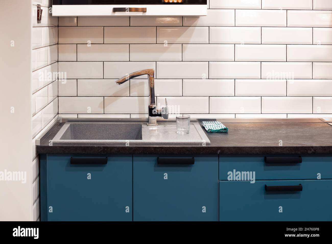Kitchen design with white brick tiles and a dark countertop with a deep