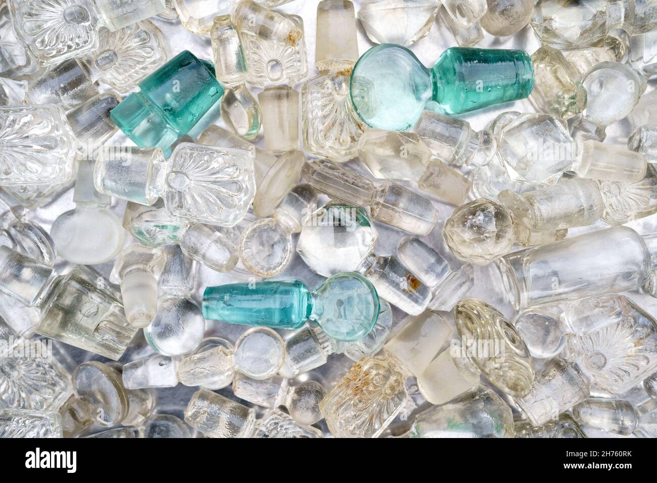 Closeup of lot of colored antique glass bottle stoppers from decanters, liquor and flasks with traces of use Stock Photo