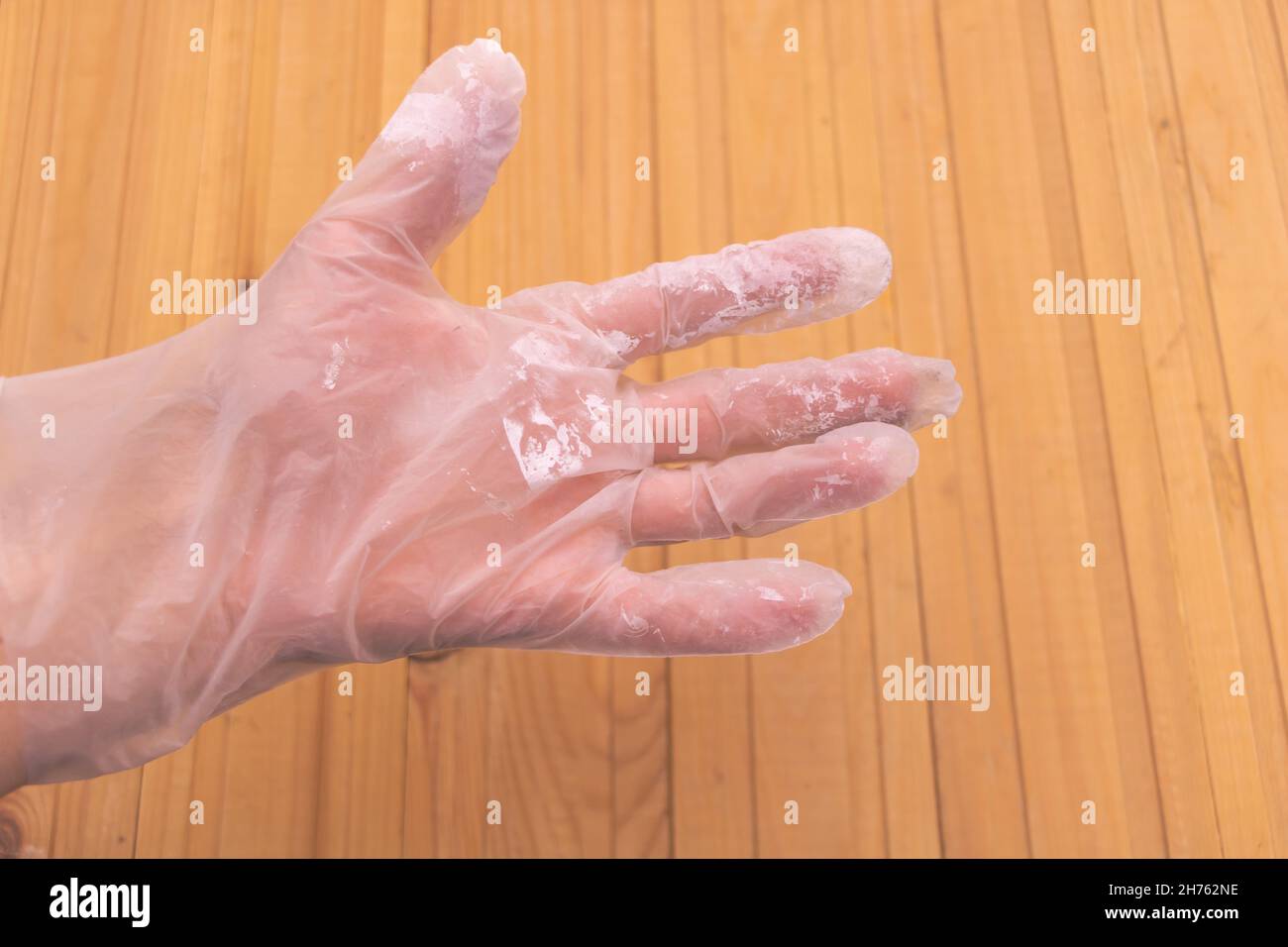 A dirty glove of plaster - worn on the hand of a worker Stock Photo