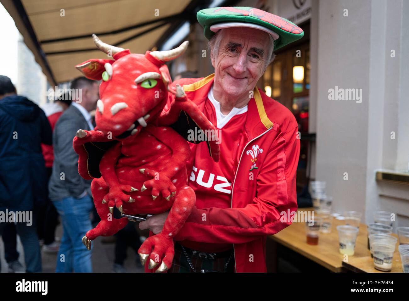 CARDIFF, WALES - NOVEMBER 20: A Wales fan poses for a photograph with a dragon puppet in Cardiff city centre ahead of the Wales v Australia rugby game Stock Photo