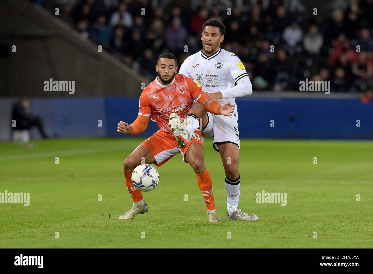 Swansea, UK. 20th Nov, 2021. Ben Cabango of Swansea city challenges Keshi Anderson of Blackpool. EFL Skybet championship match, Swansea city v Blackpool at the Swansea.com Stadium in Swansea on Saturday 20th November 2021. this image may only be used for Editorial purposes. Editorial use only, license required for commercial use. No use in betting, games or a single club/league/player publications. pic by Andrew Dowling/ Credit: Andrew Orchard sports photography/Alamy Live News Stock Photo