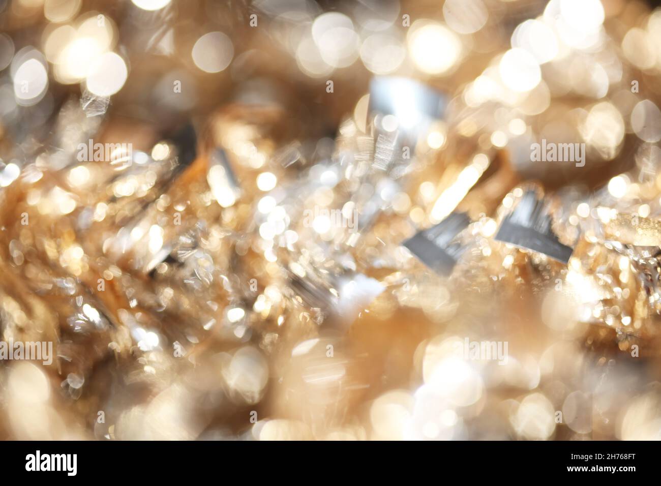 Abstract bokeh of sparkling gold and silver Christmas tinsel background Stock Photo