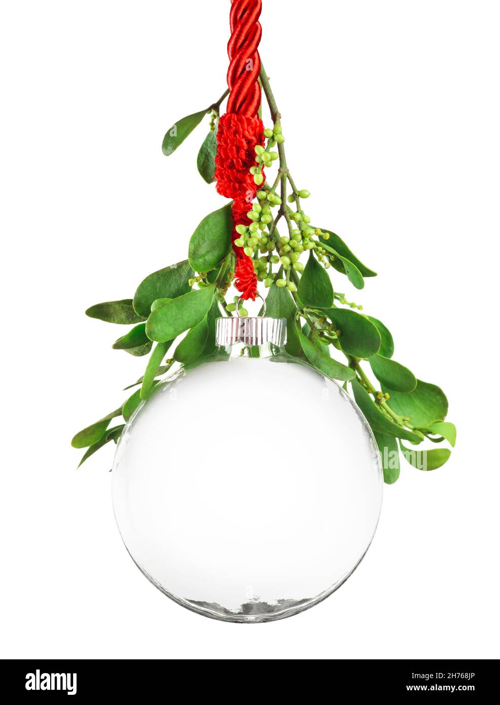 Clear Christmas ornament hanging by red ribbon rope with the bauble surrounded with green mistletoe. Stock Photo