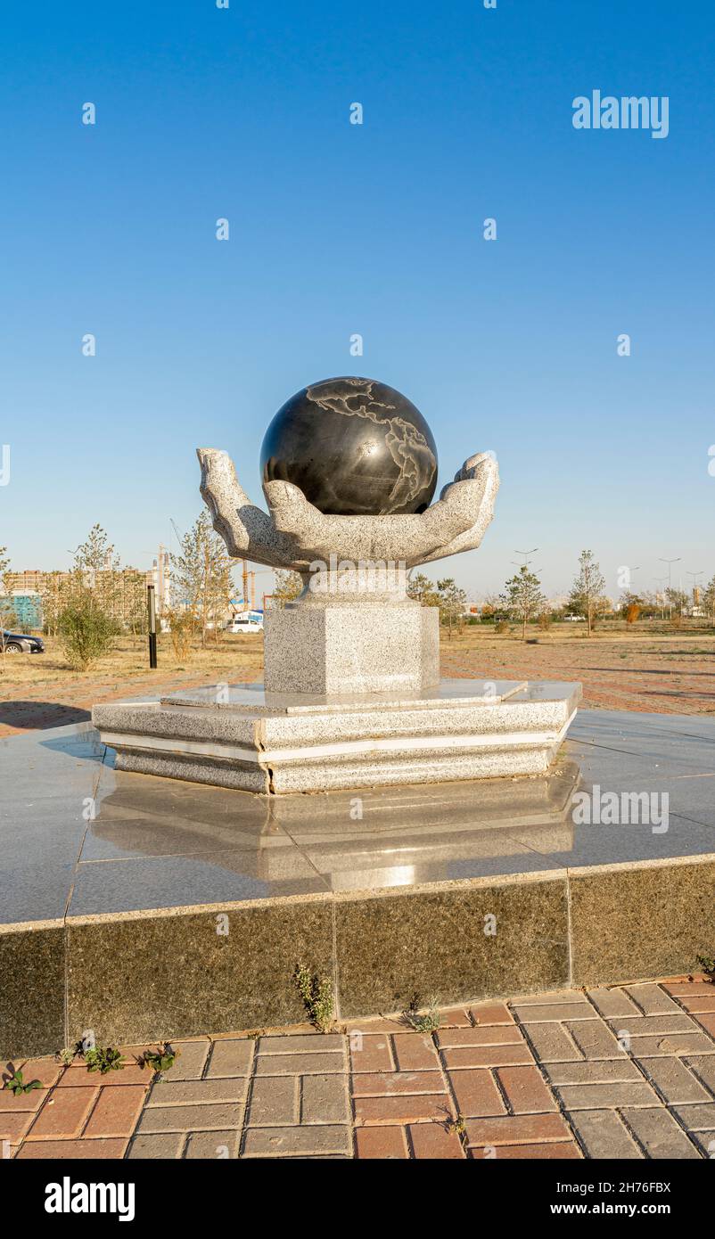 Hand holding Globe- concept conceptual sculpture, symbolizing space exploration and research. National Space Center in Astana, Nur-Sultan, Kazakhstan Stock Photo