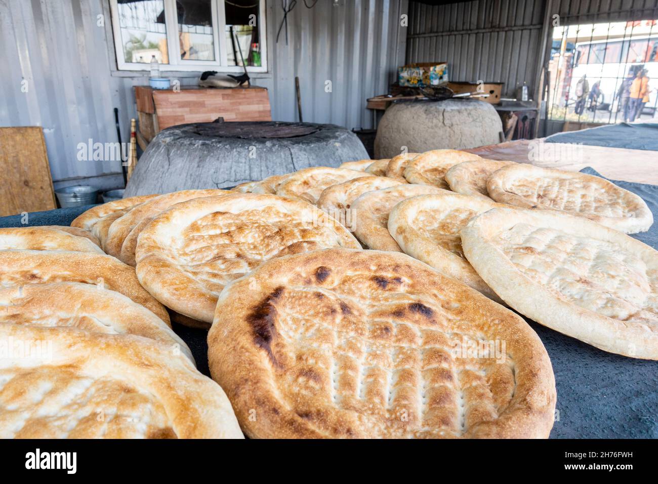Tamdyr or tandyr- traditional round bread cooked in round ovens sold in Central Asia. near Almaty, Kazakhstan Stock Photo