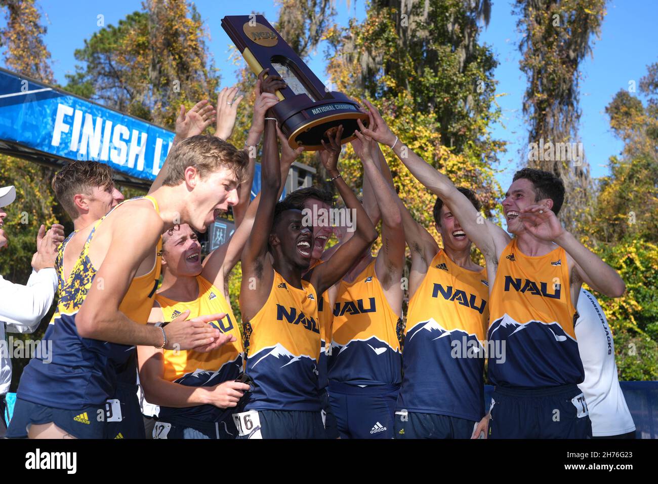 Members of the Northern Arizona Lumberjacks men's team celebrate with team trophy after defending title during the NCAA cross country championships at Stock Photo