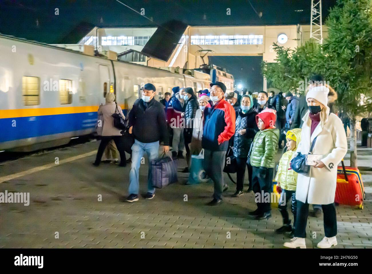 Passengers walking to board on the train arriving on the platform of Karagandy Railway stop. Kazakhstan, Central Asia Stock Photo