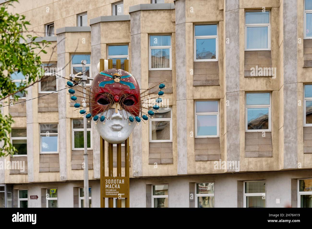 Sculpture - National Theater Award Golden Mask with an inscription in Russian in front of the Musical Theater building (built in 1936). Stock Photo