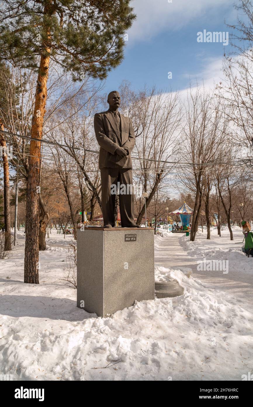 The monument to the writer Maxim Gorky stands in a snowdrift among the trees in the city's central park named after him. Vertical shot. Stock Photo