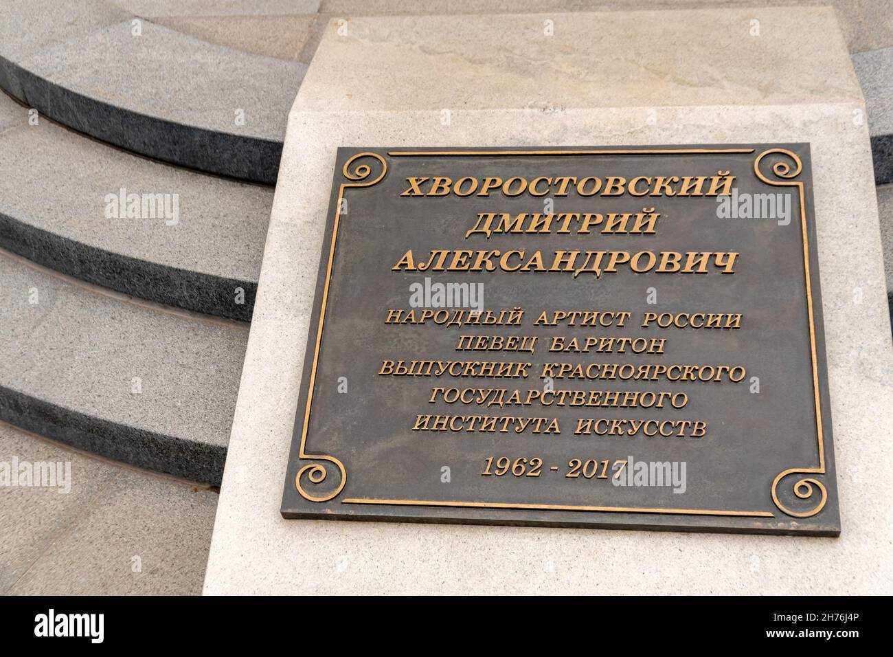 A memorial plaque at the monument to opera singer Dmitry Hvorostovsky that he graduated from the Krasnoyarsk Institute of Arts in Russian. Stock Photo