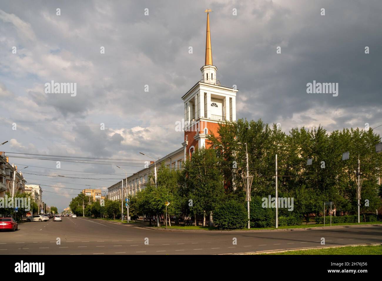 An administrative building with a spire tower is located at the corner of Karl Marx and Robespierre streets on a summer day in the city of Krasnoyarsk Stock Photo