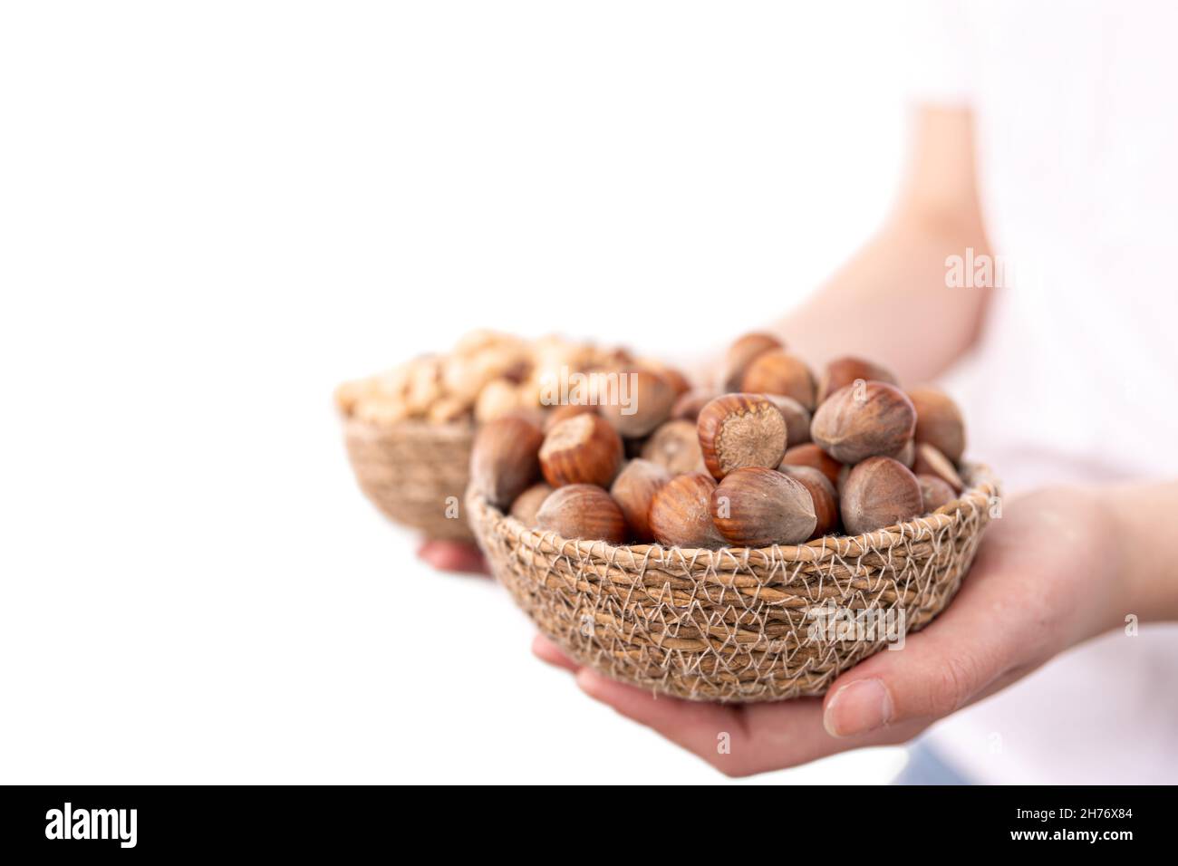 Closeup of a plate of hazelnuts and macadamia nuts in female hands Stock Photo Alamy