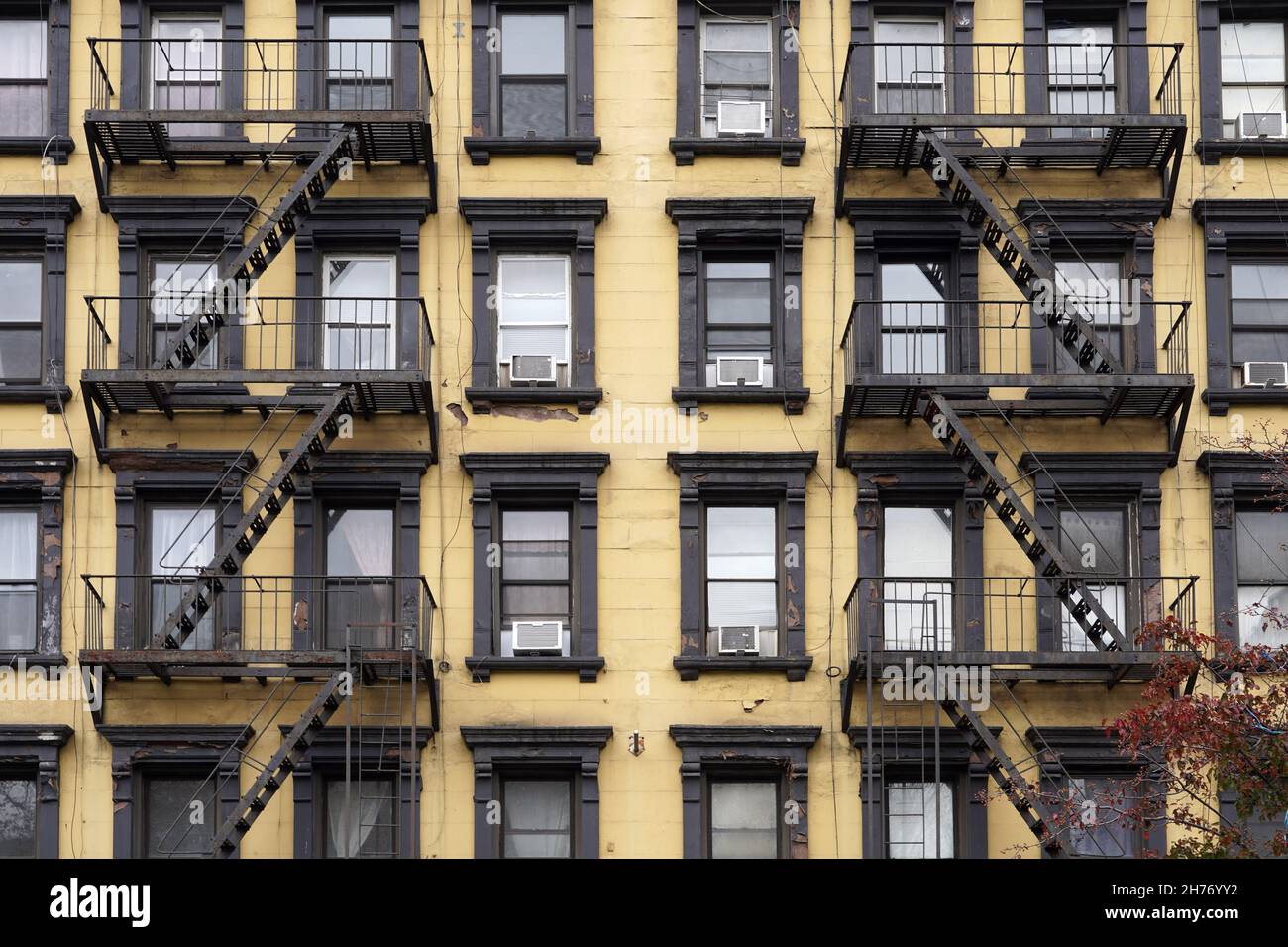 Colorful, Old fashioned Manhattan apartment building facades with external fire escape ladders Stock Photo