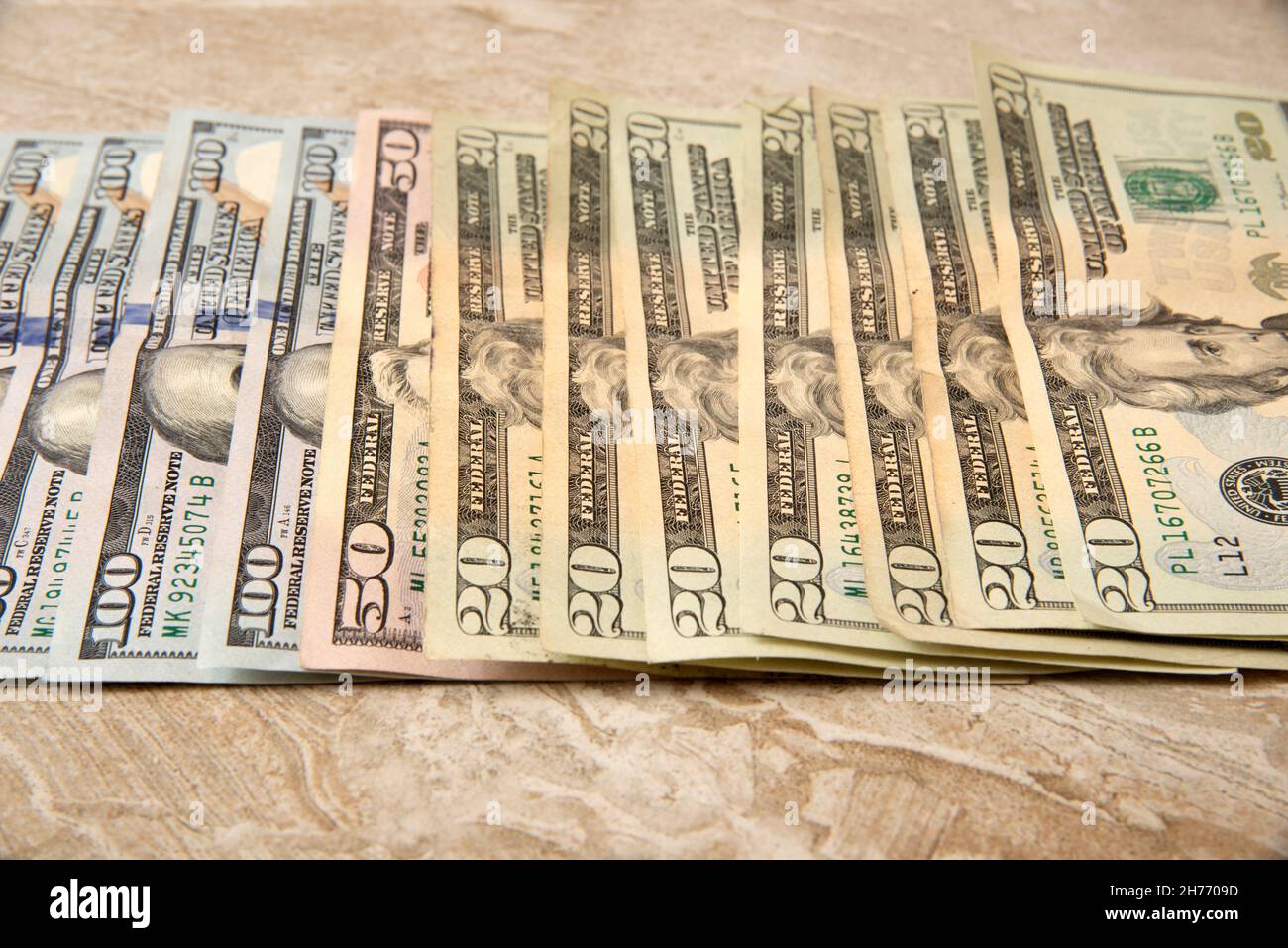 Currency in USD Hundred, Fifty and Twenty dollar bills spread out on a table Stock Photo