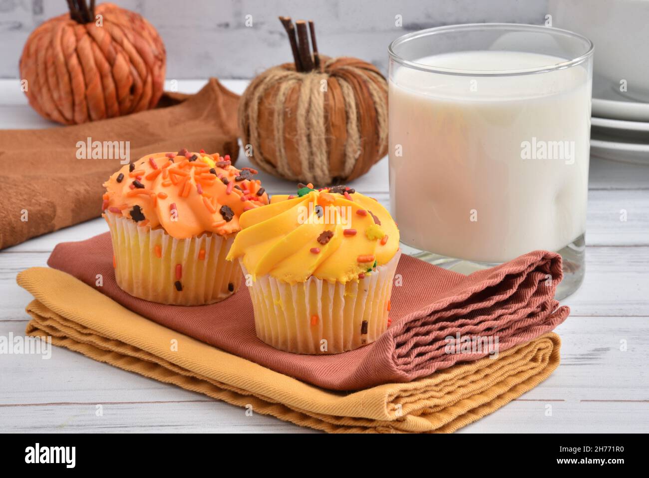 Gourmet Halloween or holiday cupcakes with a glass of milk on a rustic wooden table Stock Photo