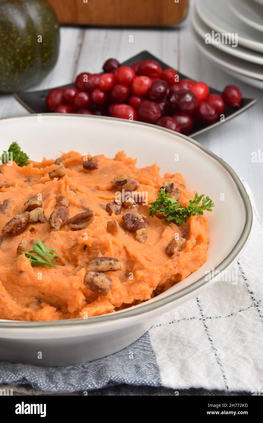 Bowl of homemade mashed sweet potatoes with glazed pecans and fresh cranberries Stock Photo