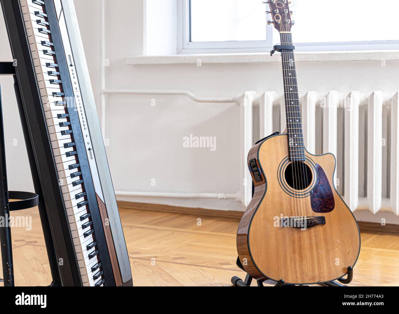 Piano keys and acoustic guitar in the interior of a bright room Stock Photo  - Alamy