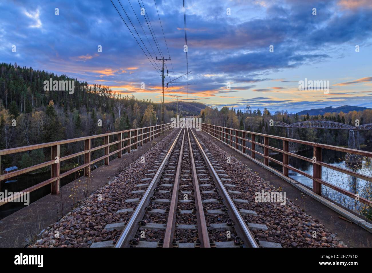 railroad bridge over river and mountain during sun down Stock Photo