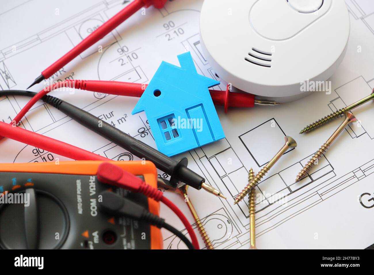 https://c8.alamy.com/comp/2H77BY3/smoke-detector-with-a-screwdriver-and-a-measuring-device-on-a-circuit-diagram-2H77BY3.jpg