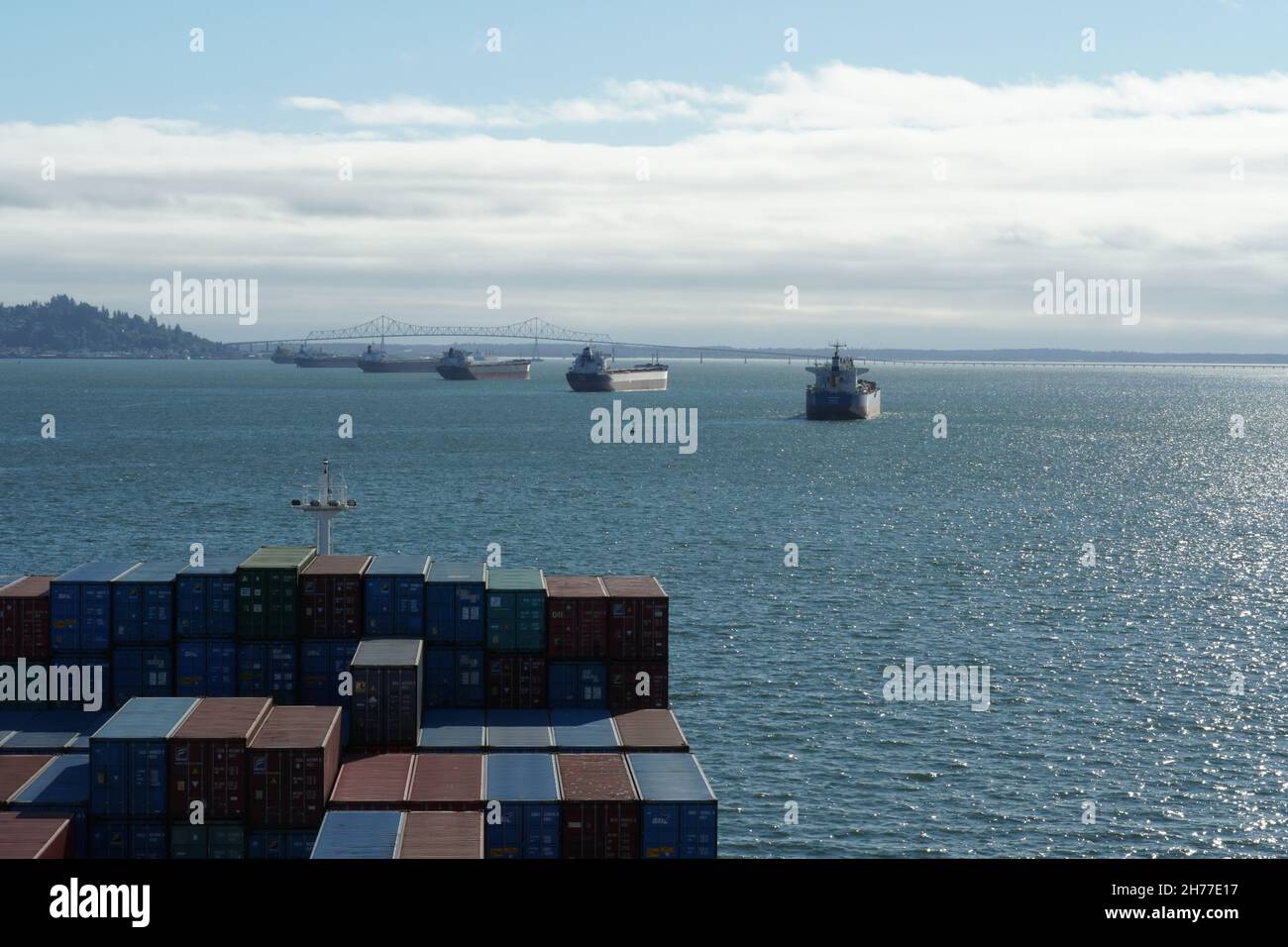 Anchored bulk cargo vessels observed from merchant container ship sailing through Columbia river, Oregon to Pacific Ocean. Stock Photo