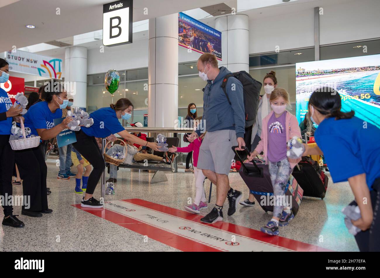 Sydney, Australia. 21st Nov, 2021. People welcome passengers from Singapore at Sydney Airport in Sydney, Australia, on Nov. 21, 2021. Australia's travel bubble with Singapore came into effect on Sunday. Credit: Bai Xuefei/Xinhua/Alamy Live News Stock Photo