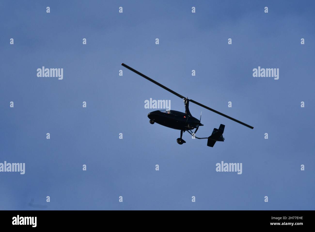 A gyroplane, gyrocopter, autogyro, flying high over rural England on an autumnal day Stock Photo