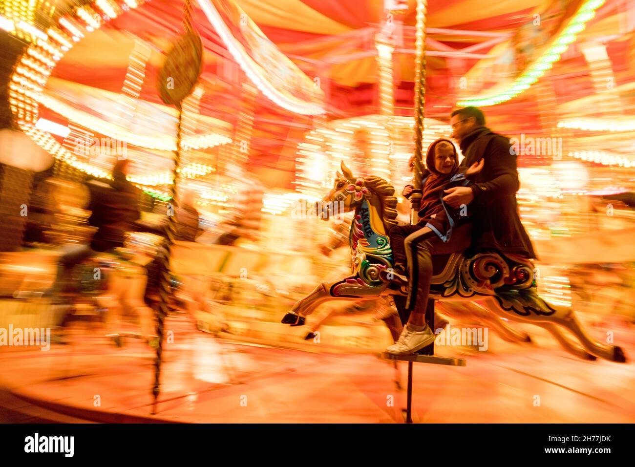 A father seen riding the merrygoround with his baby son.As Christmas