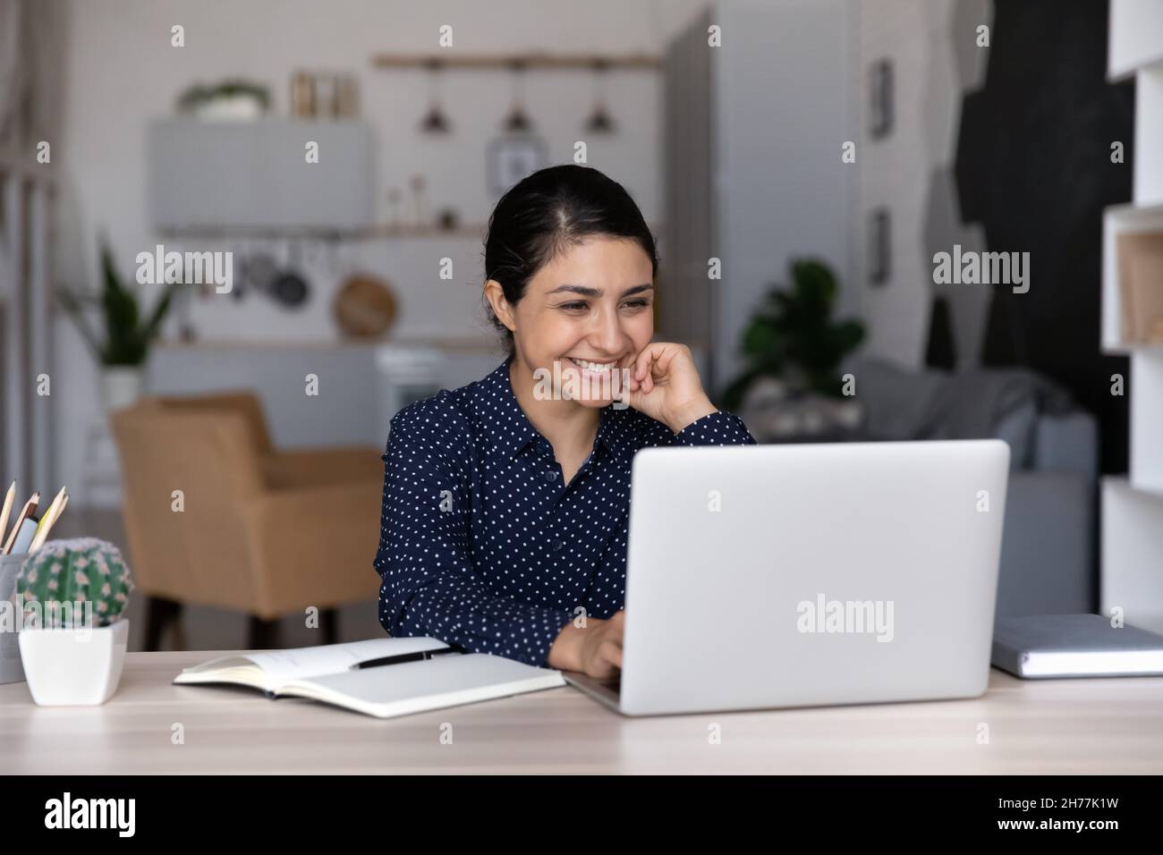 Happy young Indian ethnicity businesswoman working on computer. Stock Photo