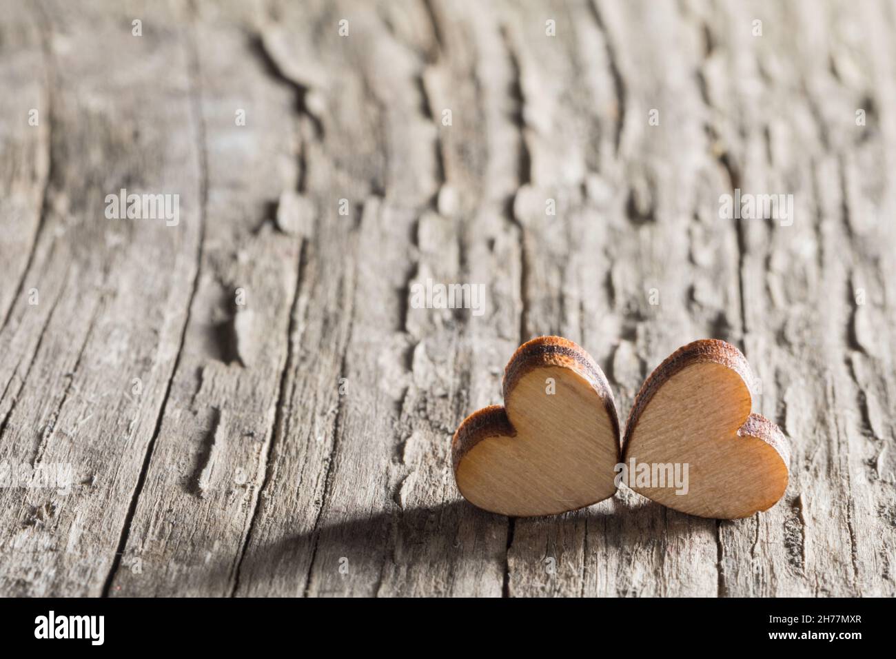Two small wooden carved hearts on rustic wood background couple relationship Valentine day concept, copy space for text Stock Photo