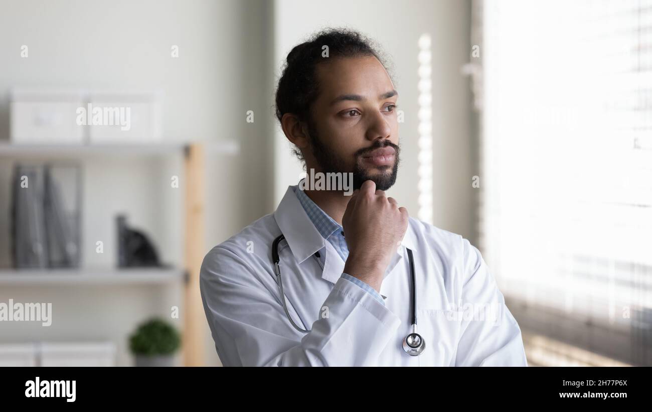 Head shot pensive African American man doctor looking in distance Stock Photo