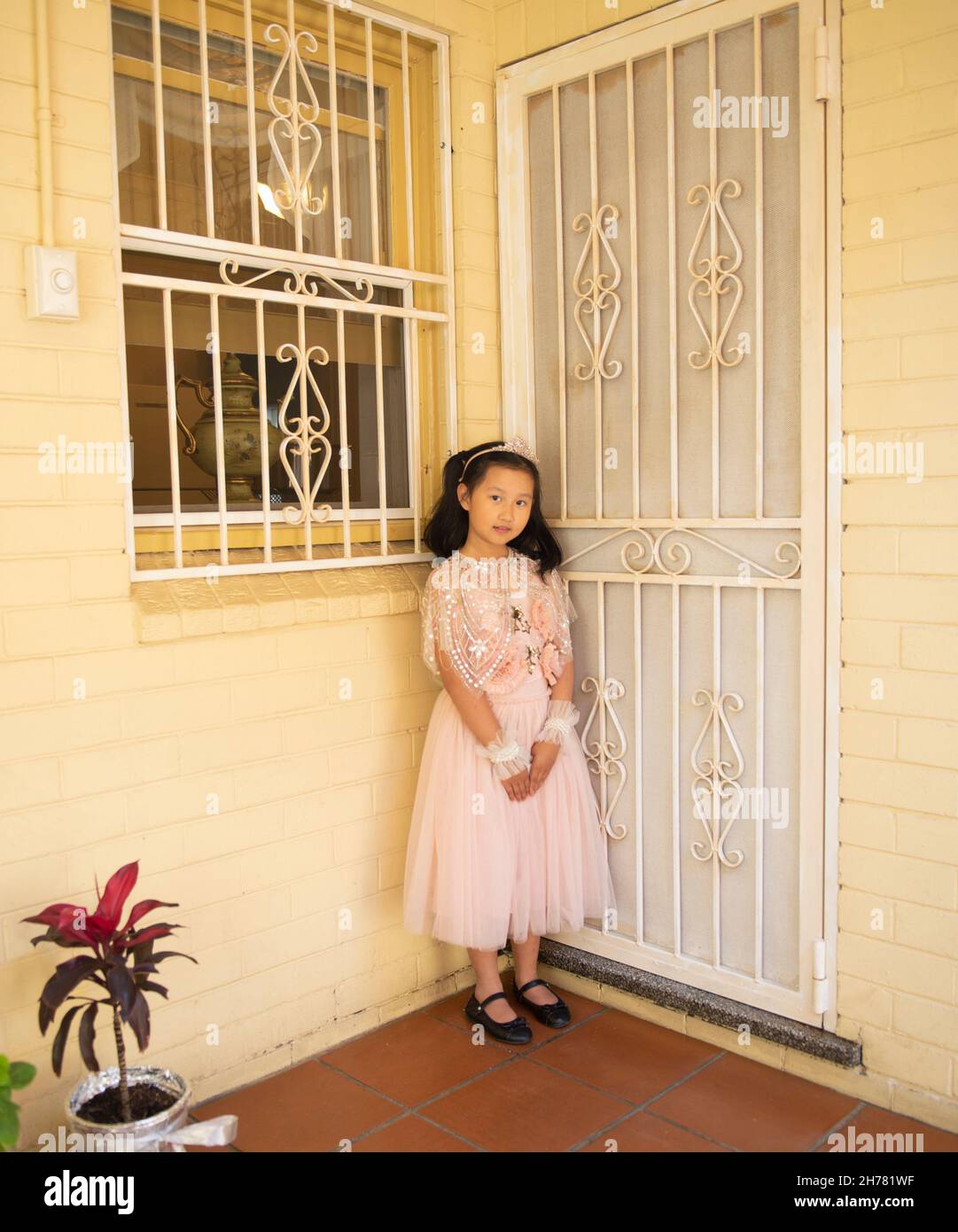Dressed up little girl standing at front door Stock Photo - Alamy