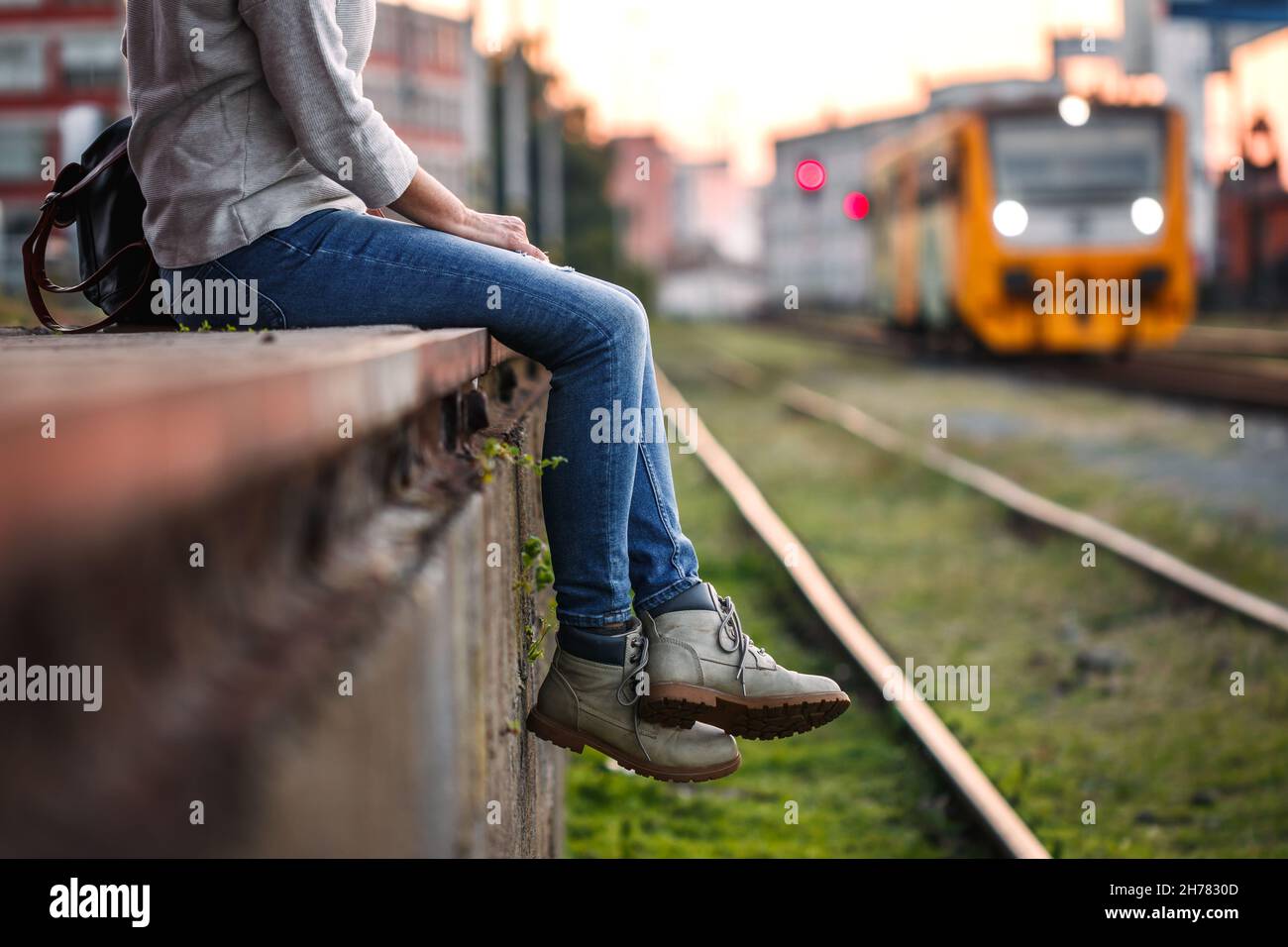 Traveler waiting for train at railway station. Woman with hiking boots