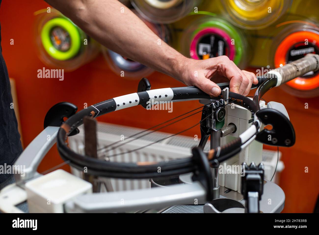 Process of stringing a tennis racket in a tennis shop, new tennis