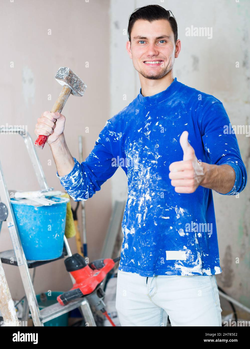 Smiling builder showing thumb up Stock Photo