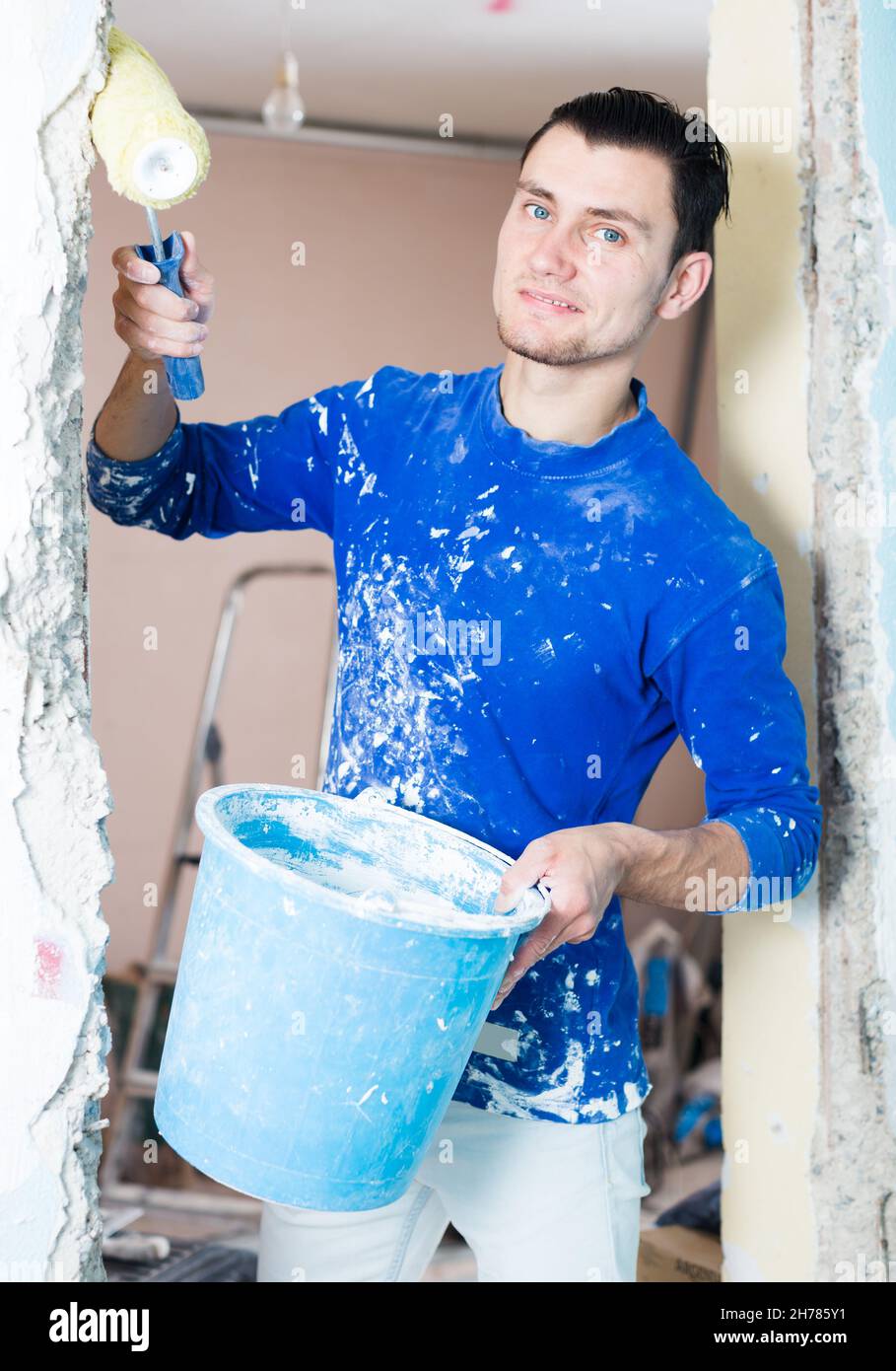 Handyman with priming roller making prime coating Stock Photo Alamy