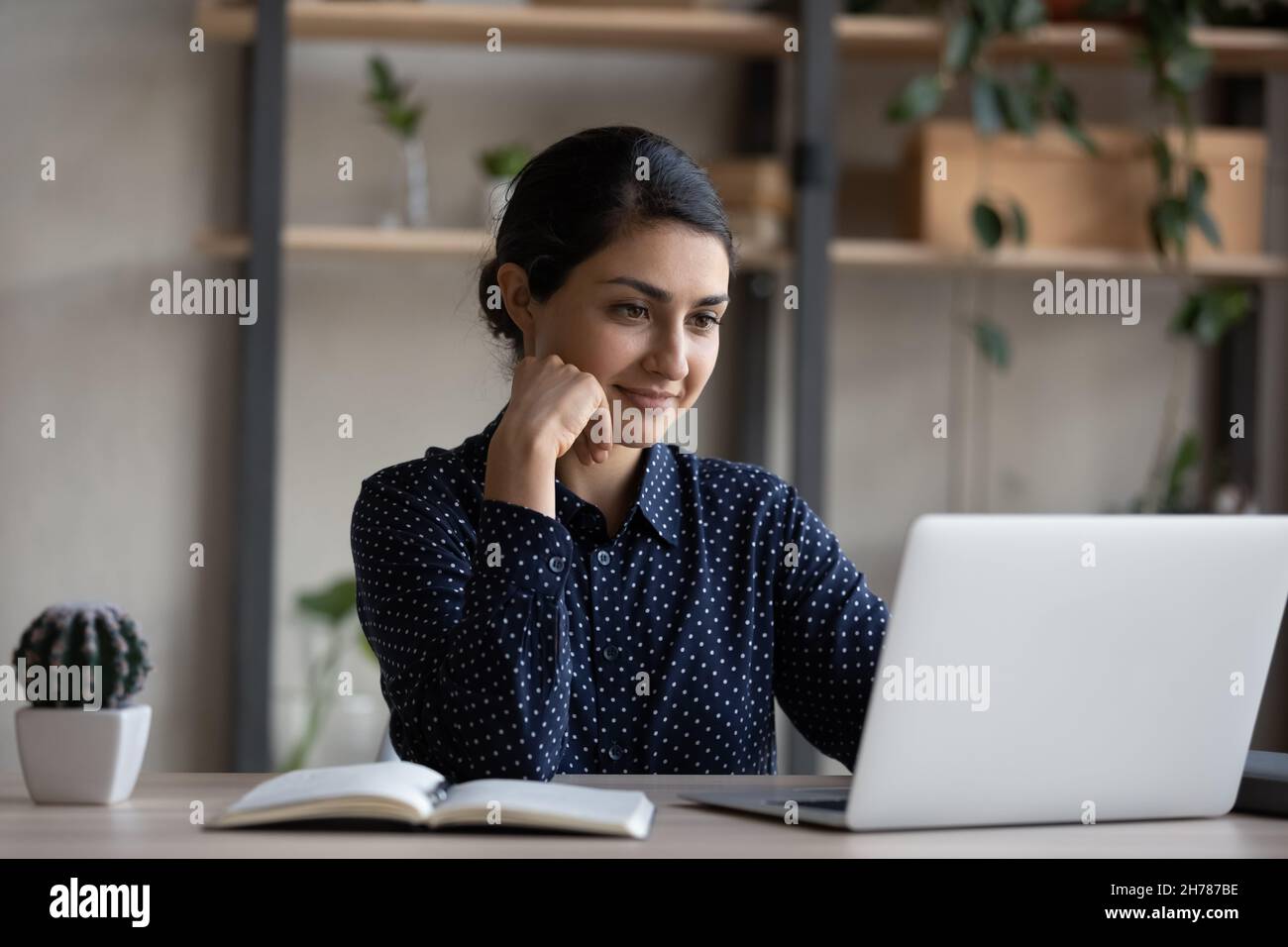 Happy pensive young Indian businesswoman working on computer Stock ...