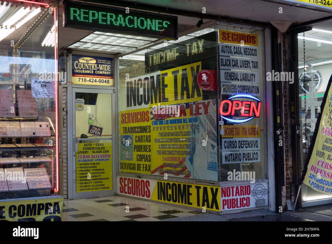 Spanish signs in a storefront in Queens that prepares taxes, gives driver's ed courses and various other financial services. Jackson Heights, New York Stock Photo
