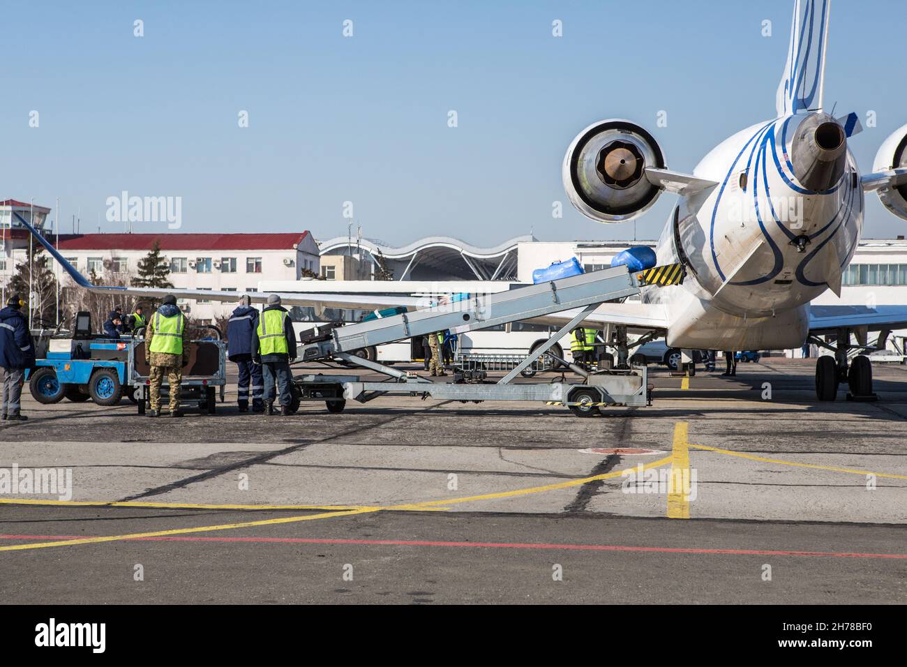 baggage loading at airport in winter. Luggage in carts near aircraft in winter. Passenger aircraft in winter at airport loaded baggage before departur Stock Photo