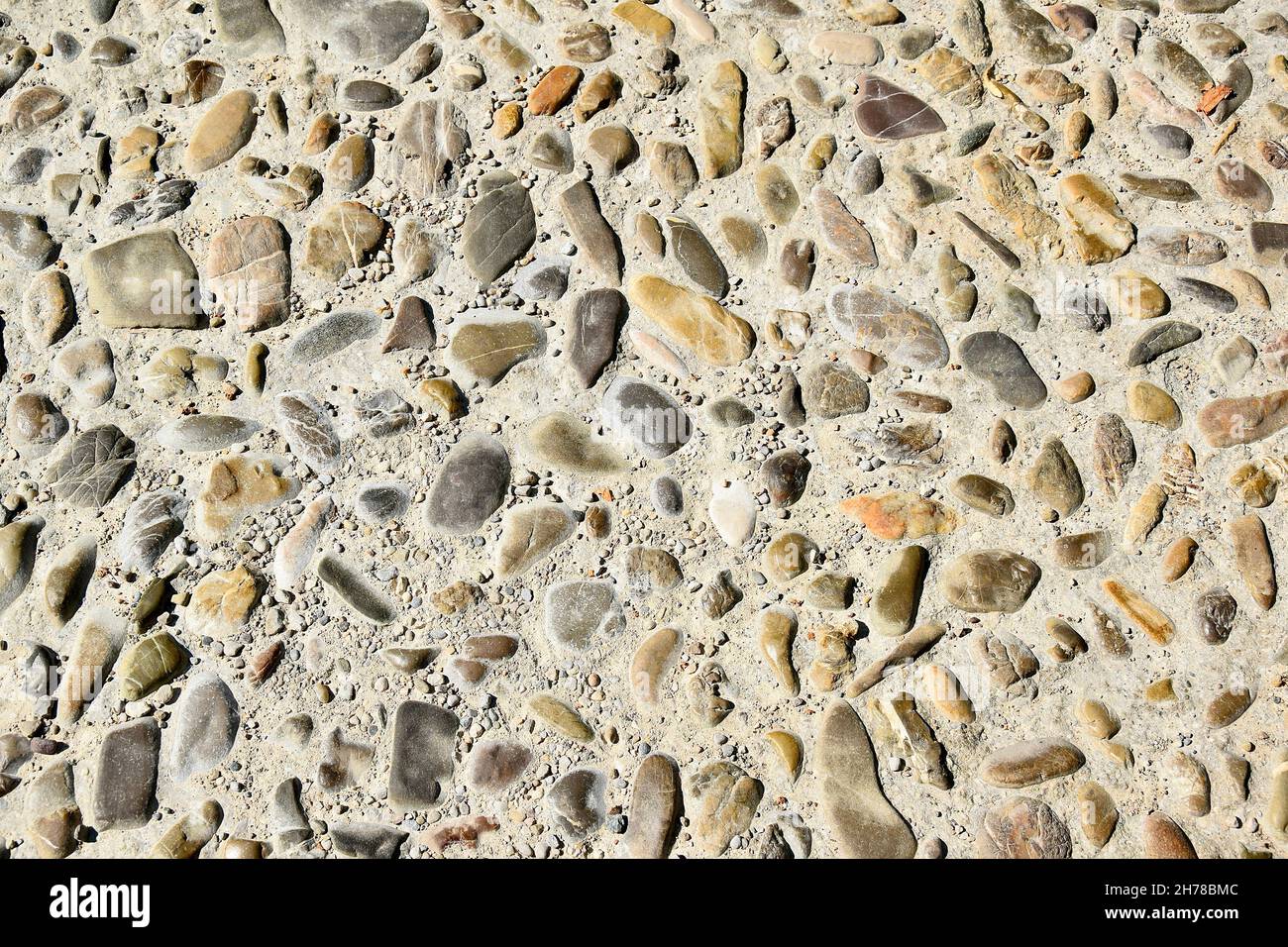 Kieselsteine unterschiedlicher Größe und Farbe als freundlicher und unverwechselbarer Bodenbelag nach altem Muster Stock Photo