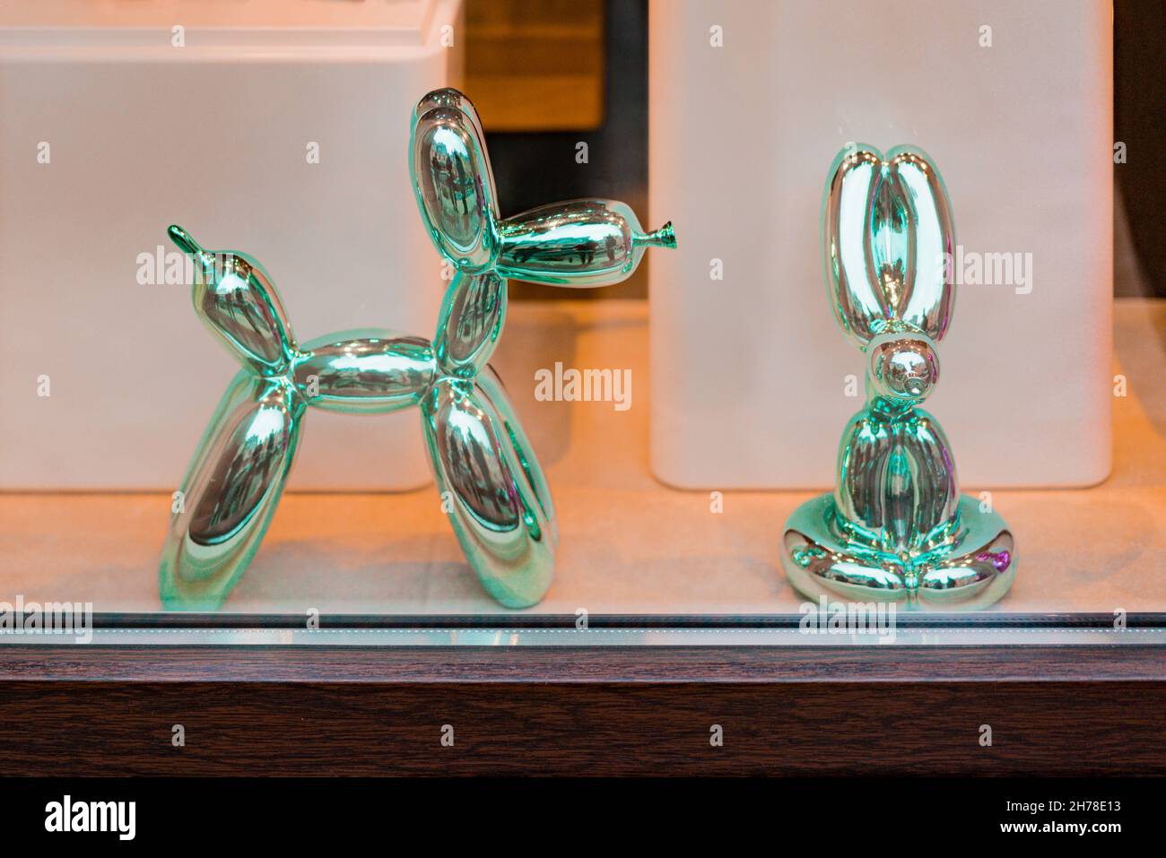 Green balloons glass dog and rabbit statues behind the window. Shop