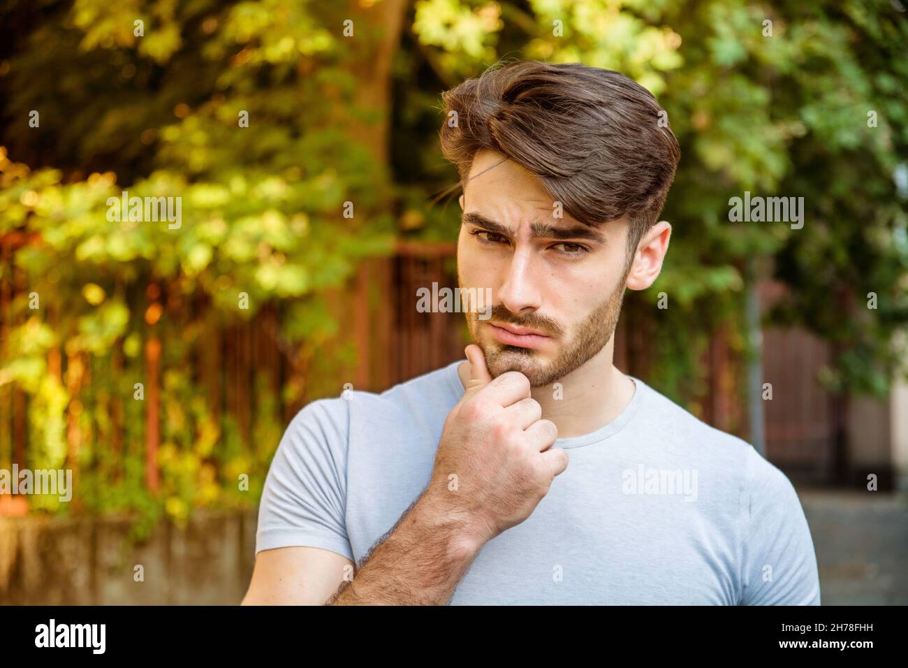 Confused young man scratching his head, looking up Stock Photo Alamy