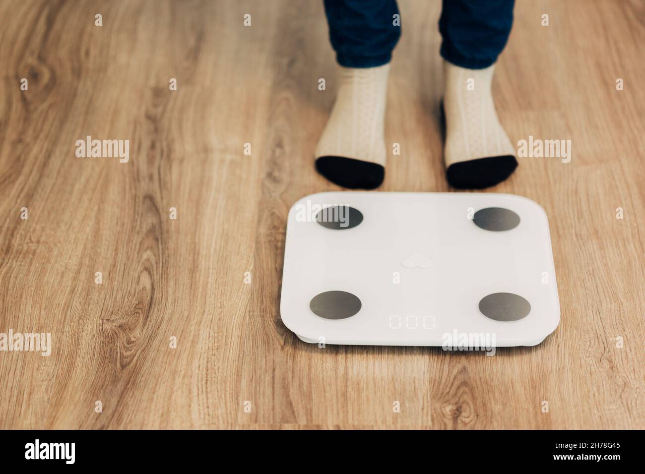 Girl Measures Weight on Smart Scales. Modern Electronic Device. Stock Photo