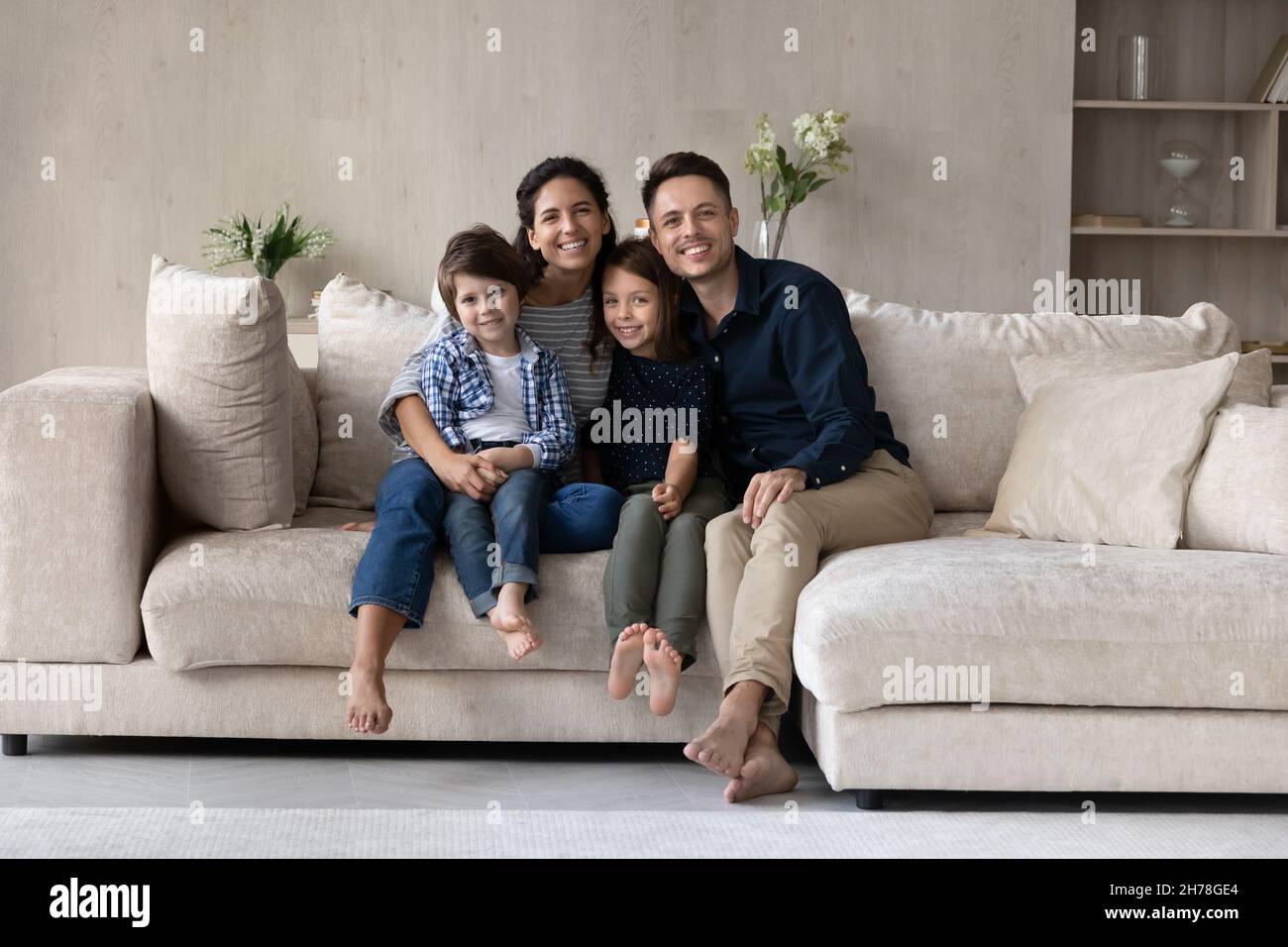 Couple and children looking at camera pose for family portrait Stock Photo