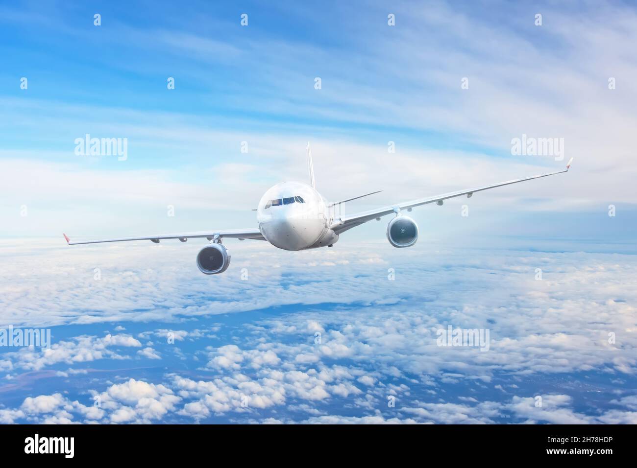 Passenger airliner flight in the blue sky among the clouds Stock Photo ...