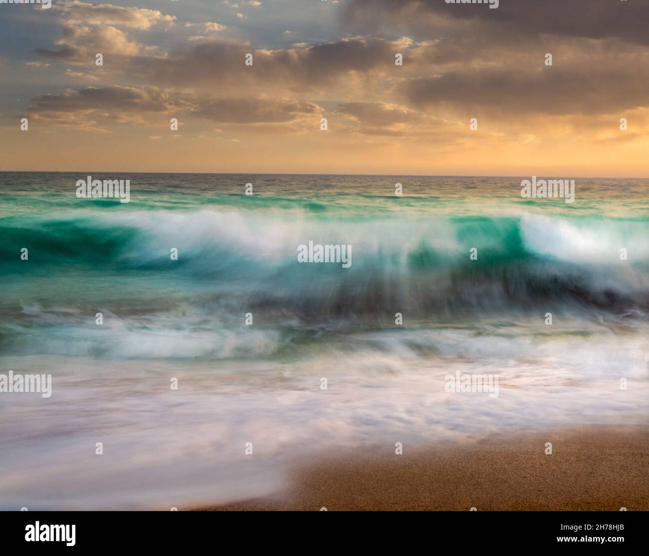 long exposure shot from the waves in the beach of Chabahar at sunset located in baluchistan, iran. waves hitting the rocks over oman sea. beach with c Stock Photo