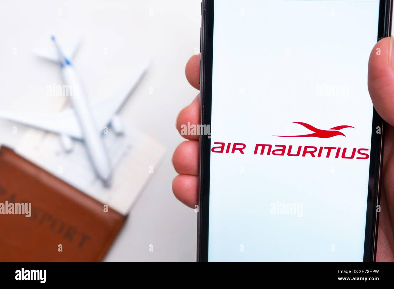 Air Mauritius Airline app on a smartphone screen in mans hand. A toy