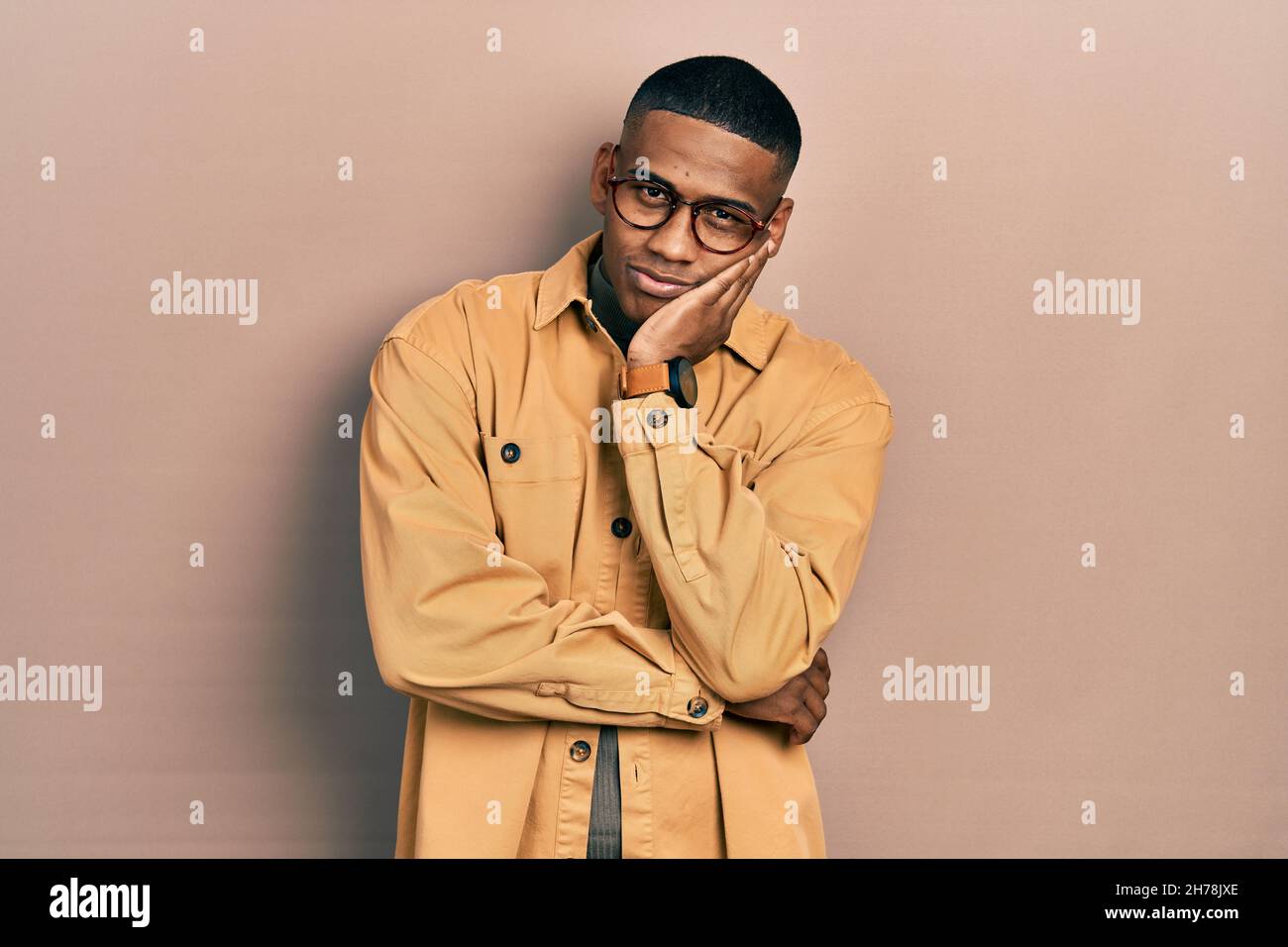 Young black man wearing casual clothes and glasses thinking looking ...