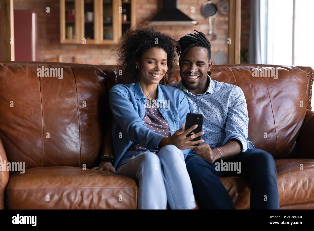 Happy millennial African American family couple using cellphone Stock ...