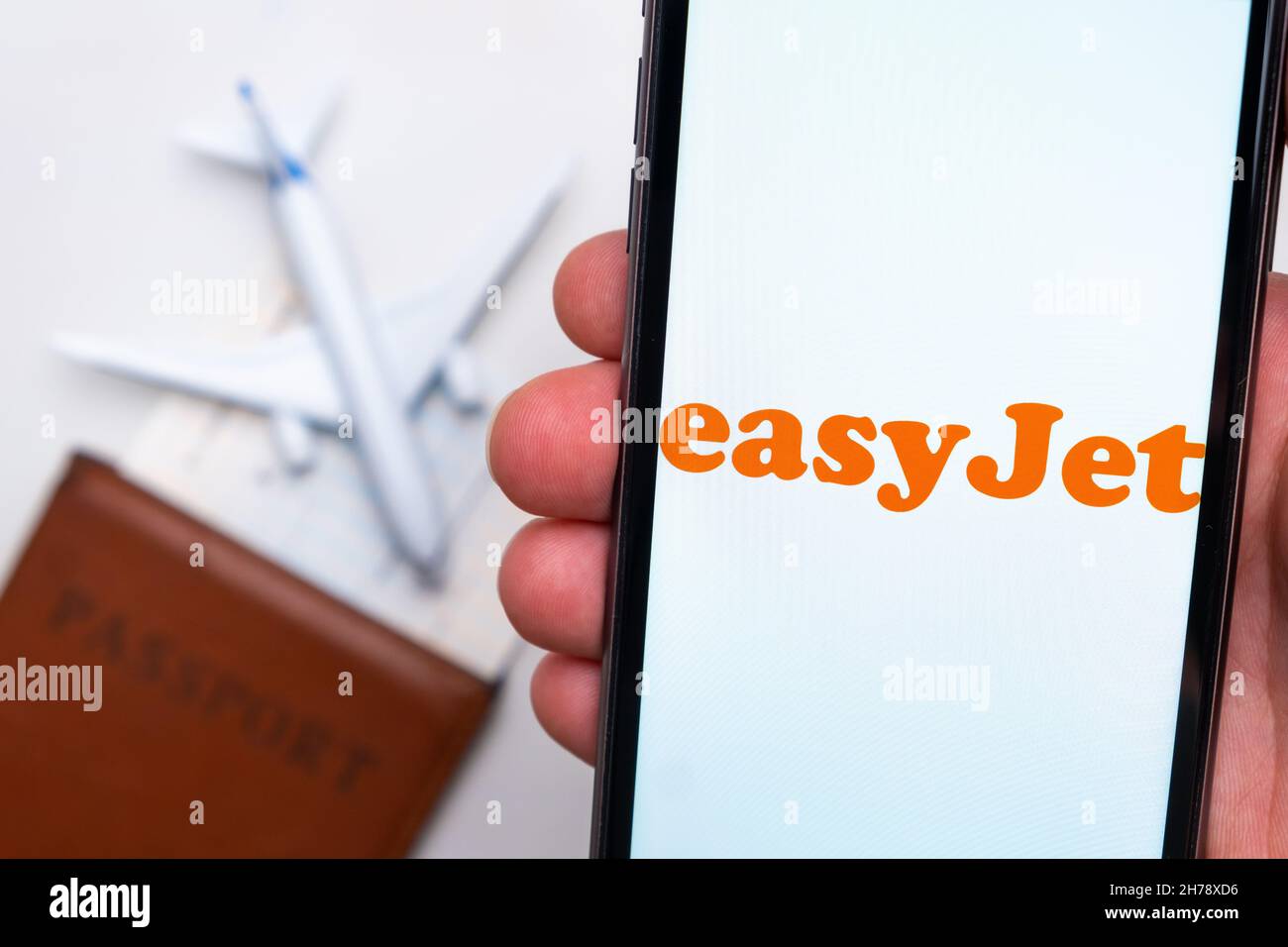 EasyJet Airline app on a smartphone screen with a plane and passport on the background. The concept of travel app. November 2021, San Francisco, USA Stock Photo